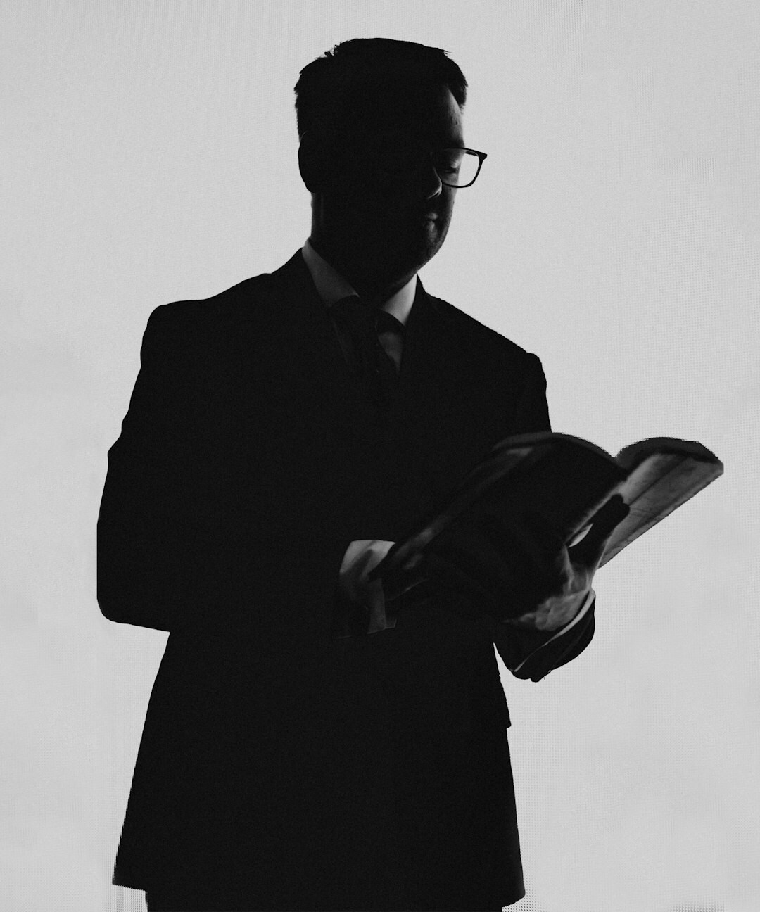 Male journalist with glasses holding a notebook